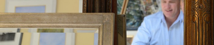 Keith Wilkinson picture framer seen in mirror with frames